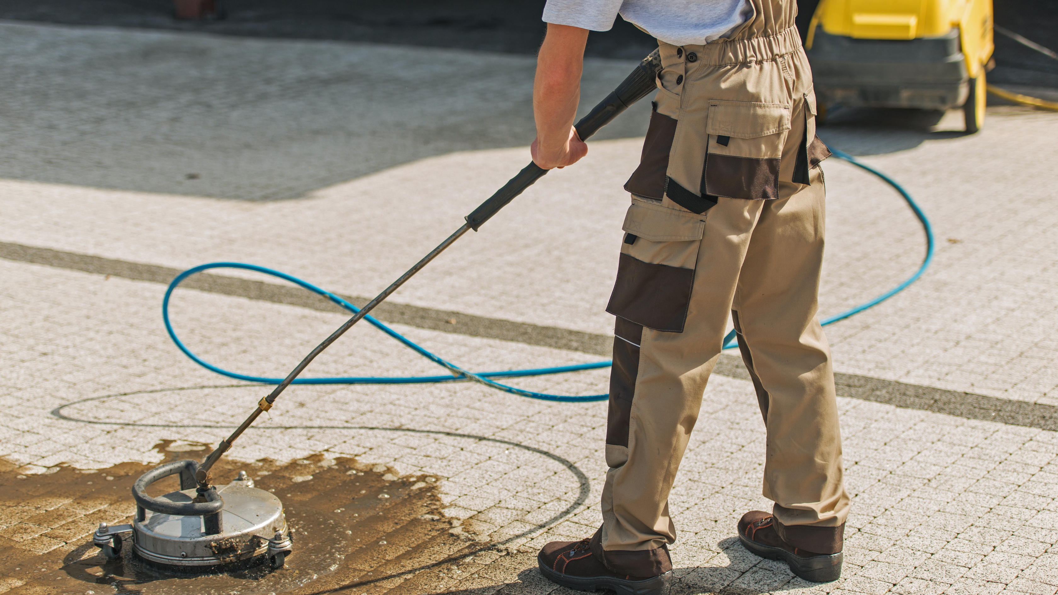 Photo of a technician using a mechanical polishing machine on a customer driveway.