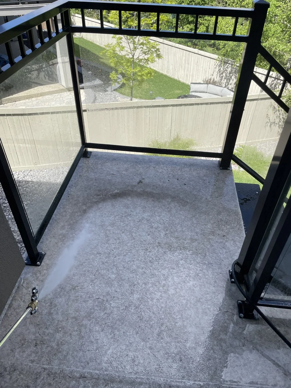 Photo of a wet balcony showing the performance of power-wash cleaning.