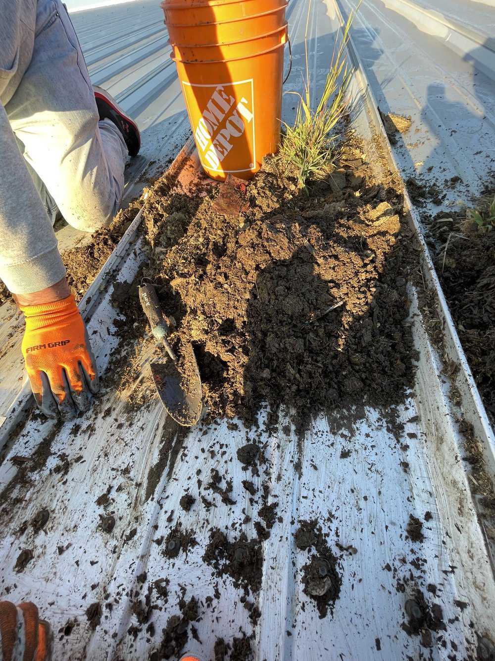 A Capt. Clean worker cleans dirt out of residential gutters.